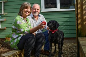 Mary and Brian Atkins smiling with dog